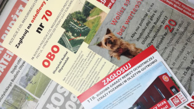 Zdjęcie przedstawia przykładowe ulotki leżące w nieładzie na stole
