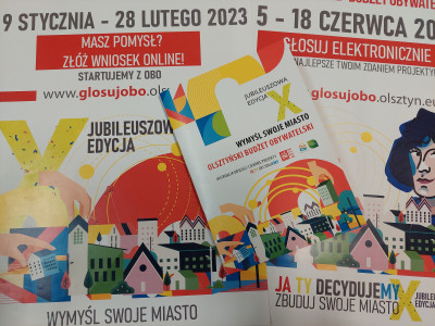 Zdjęcie przedstawia dwa plakaty dotyczące budżetu obywatelskiego oraz okładkę katalogu opisującego procedurę OBO.